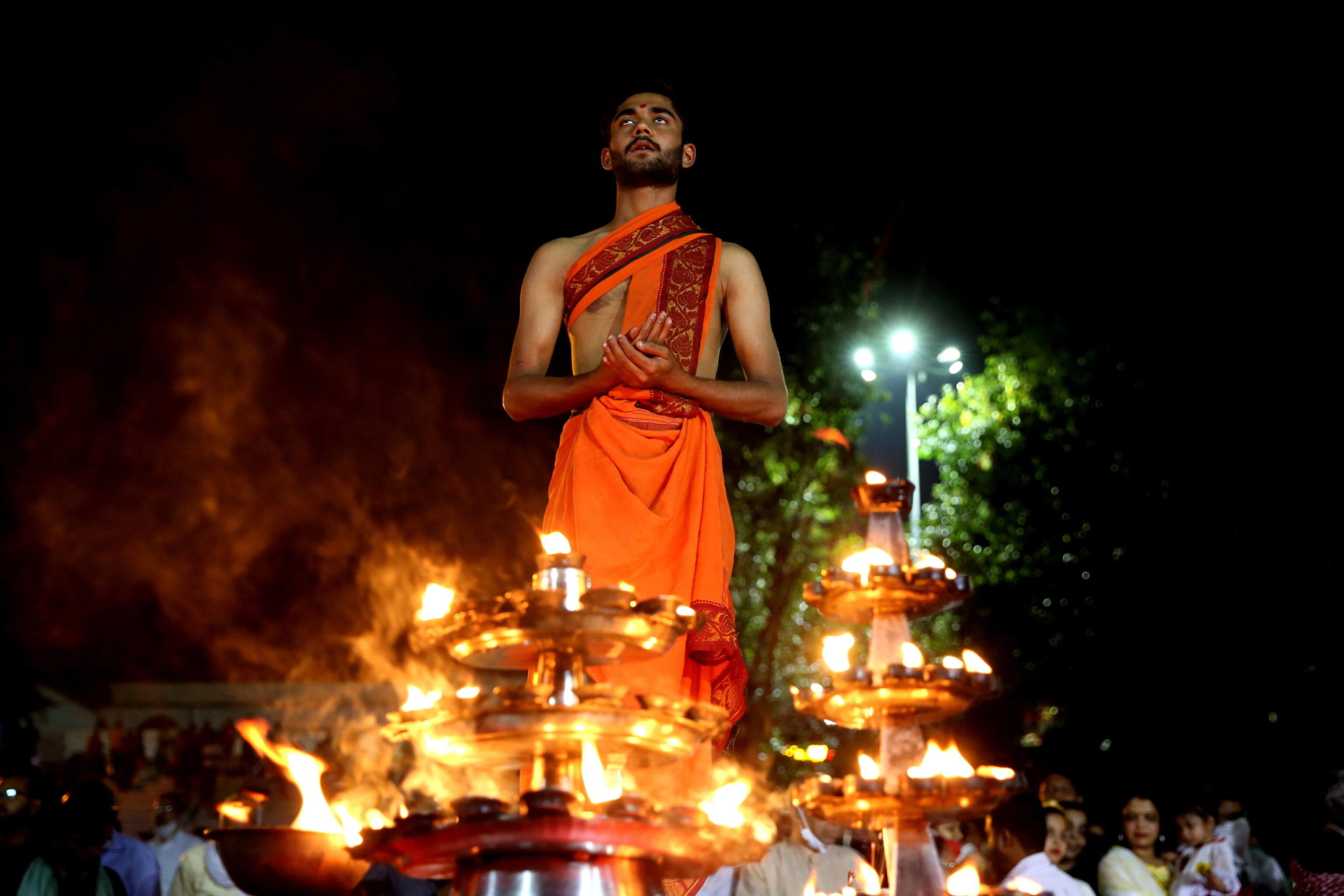 Un sacerdote in preghiera rivolto verso il fiume Narmada