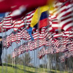 Un cadetto posiziona una bandiera americana alla Pepperdine University di Malibu