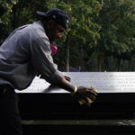 Un inserviente pulisce le targhe attorno alle fontane commemorative dell'11 settembre a New York Un inserviente pulisce le targhe attorno alle fontane commemorative dell'11 settembre a New York