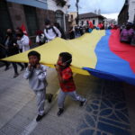 Bambini reggono la bandiera dell'Ecuador nel corteo di protesta Bambini reggono la bandiera dell'Ecuador nel corteo di protesta