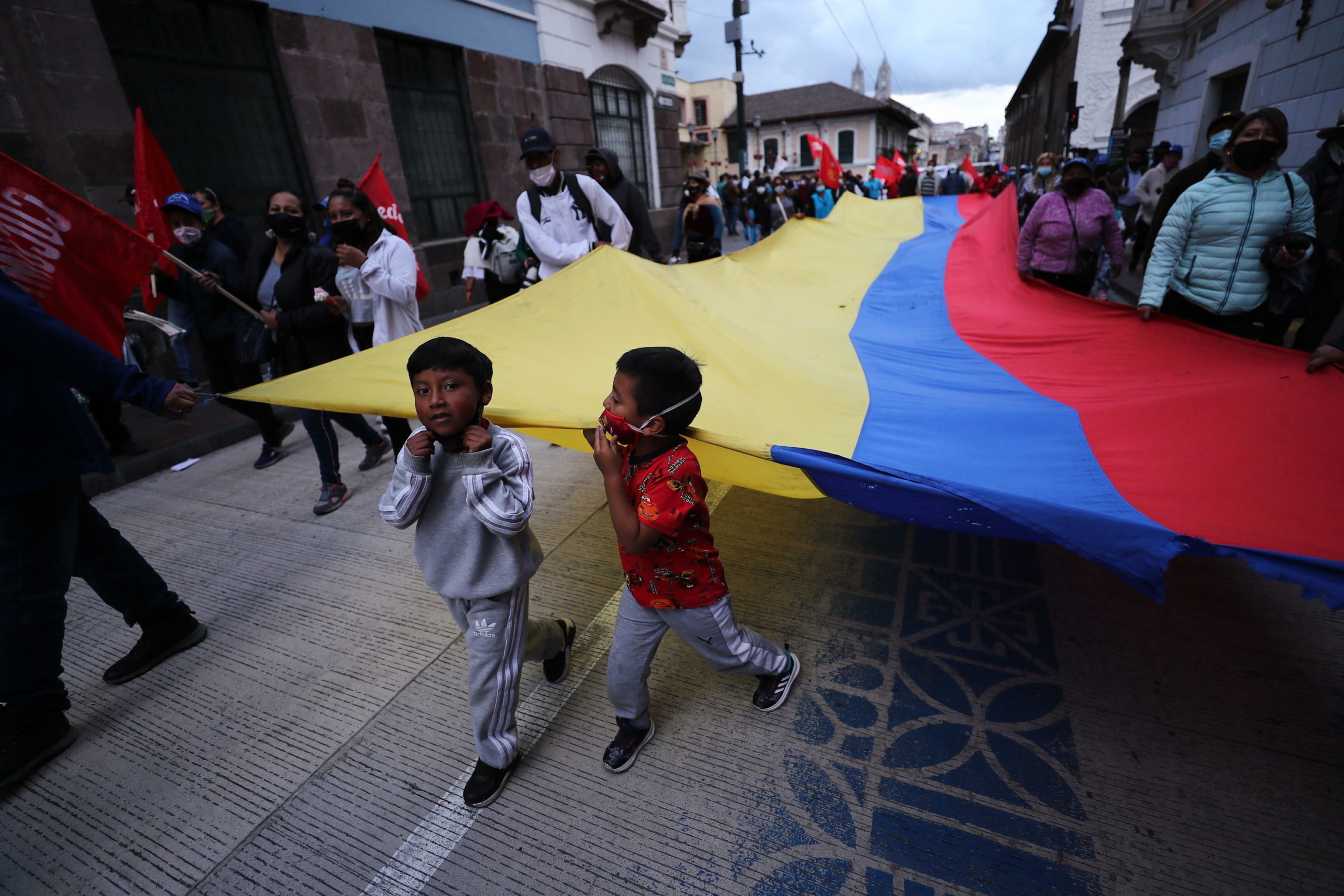 Bambini reggono la bandiera dell'Ecuador nel corteo di protesta