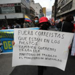 Un manifestante accusa con un cartello il Ministero del lavoro ecuadoregno Un manifestante accusa con un cartello il Ministero del lavoro ecuadoregno