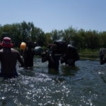 Uomini sotto sforzo cercano di raggiungere l'altra sponda Uomini sotto sforzo cercano di raggiungere l'altra sponda