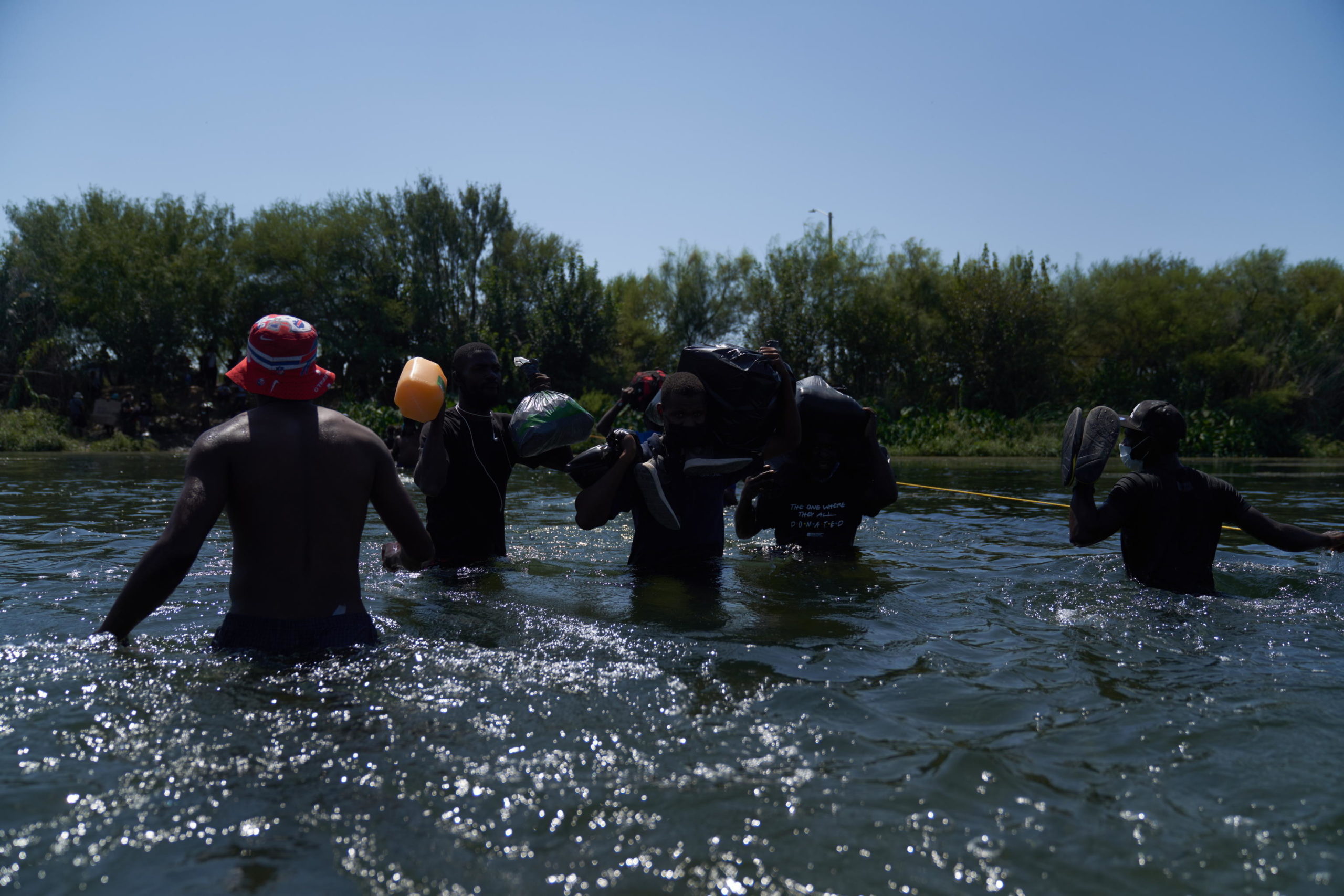 Uomini sotto sforzo cercano di raggiungere l'altra sponda Uomini sotto sforzo cercano di raggiungere l'altra sponda