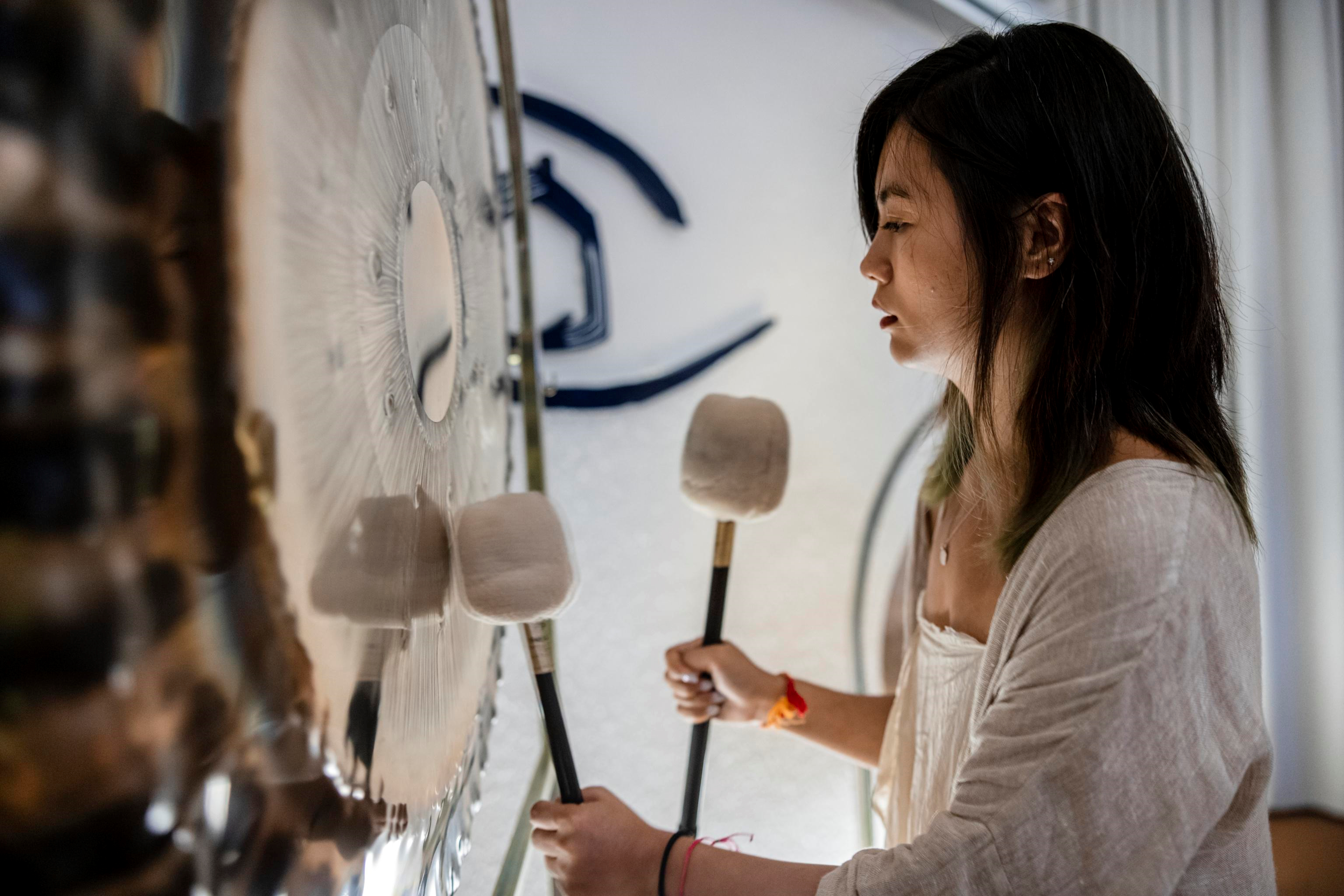 Una donna suona uno strumento simile a un gong