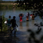 Donne e uomini cercano di preservare i loro beni dalle acque Donne e uomini cercano di preservare i loro beni dalle acque