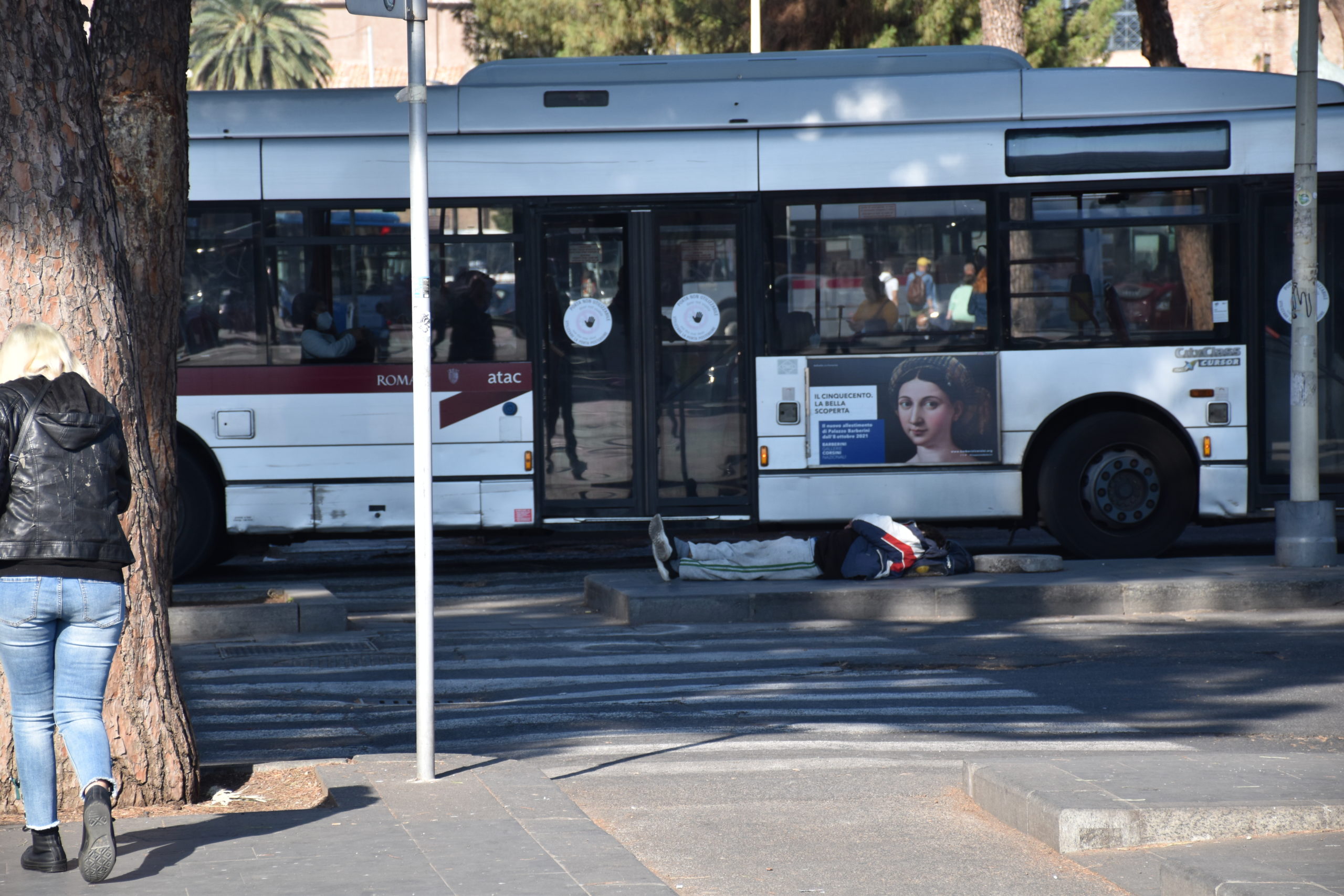 Un clochard dorme nei pressi della fermata degli autobus a piazza dei Cinquecento