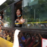 I prigionieri rilasciati salutano i loro amici e familiari dai finestrini di un autobus, fuori dalla prigione di Insein, a Yangon