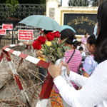 Una donna tiene dei fiori mentre aspetta un familiare fuori dalla prigione Una donna tiene dei fiori mentre aspetta un familiare fuori dalla prigione