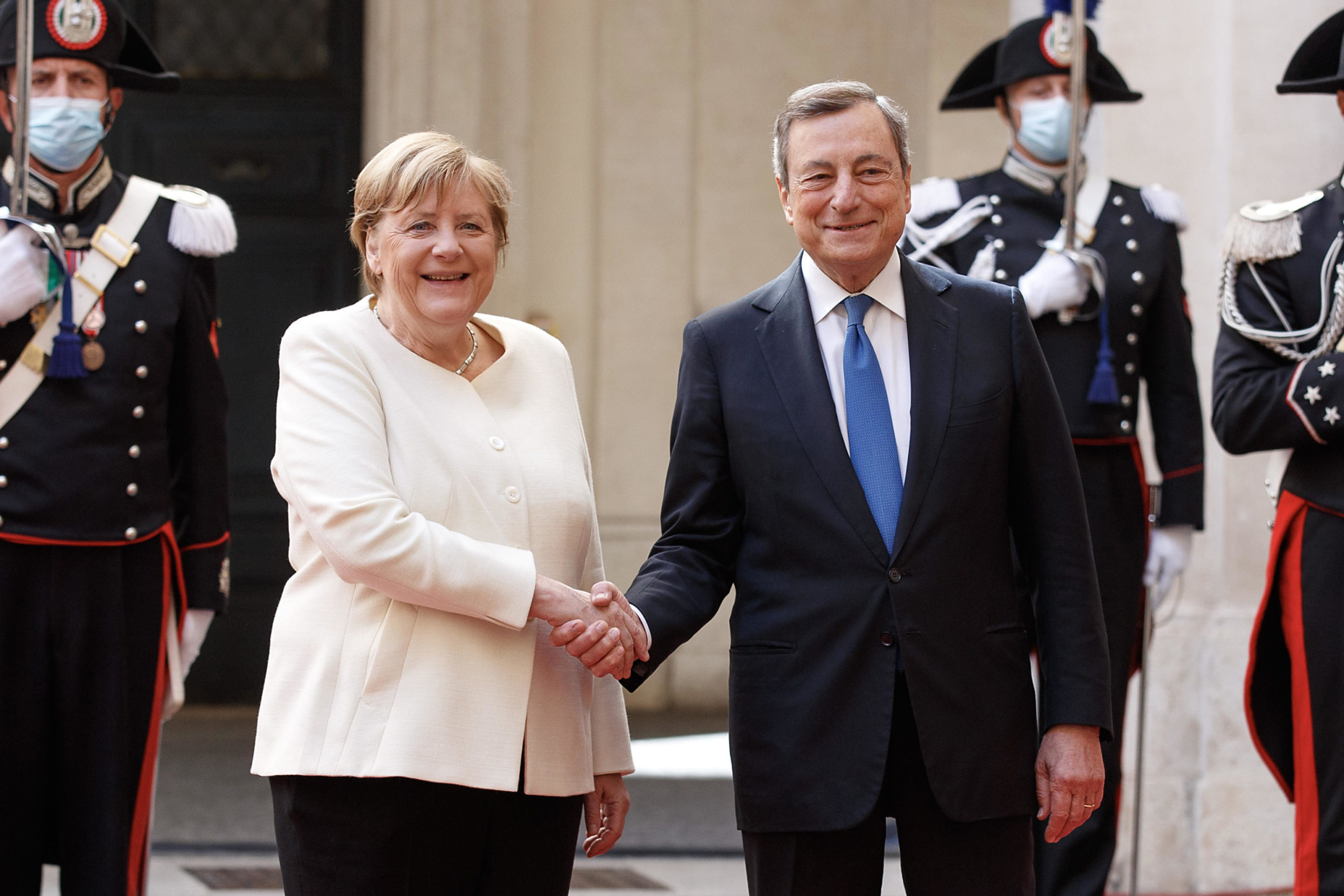 Il saluto tra il premier italiano Mario Draghi e la cancelliera uscente Angela Merkel