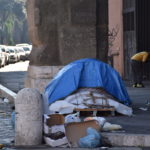 Cartoni davanti a una tenda di alcuni senzatetto nella zona di Castro Pretorio