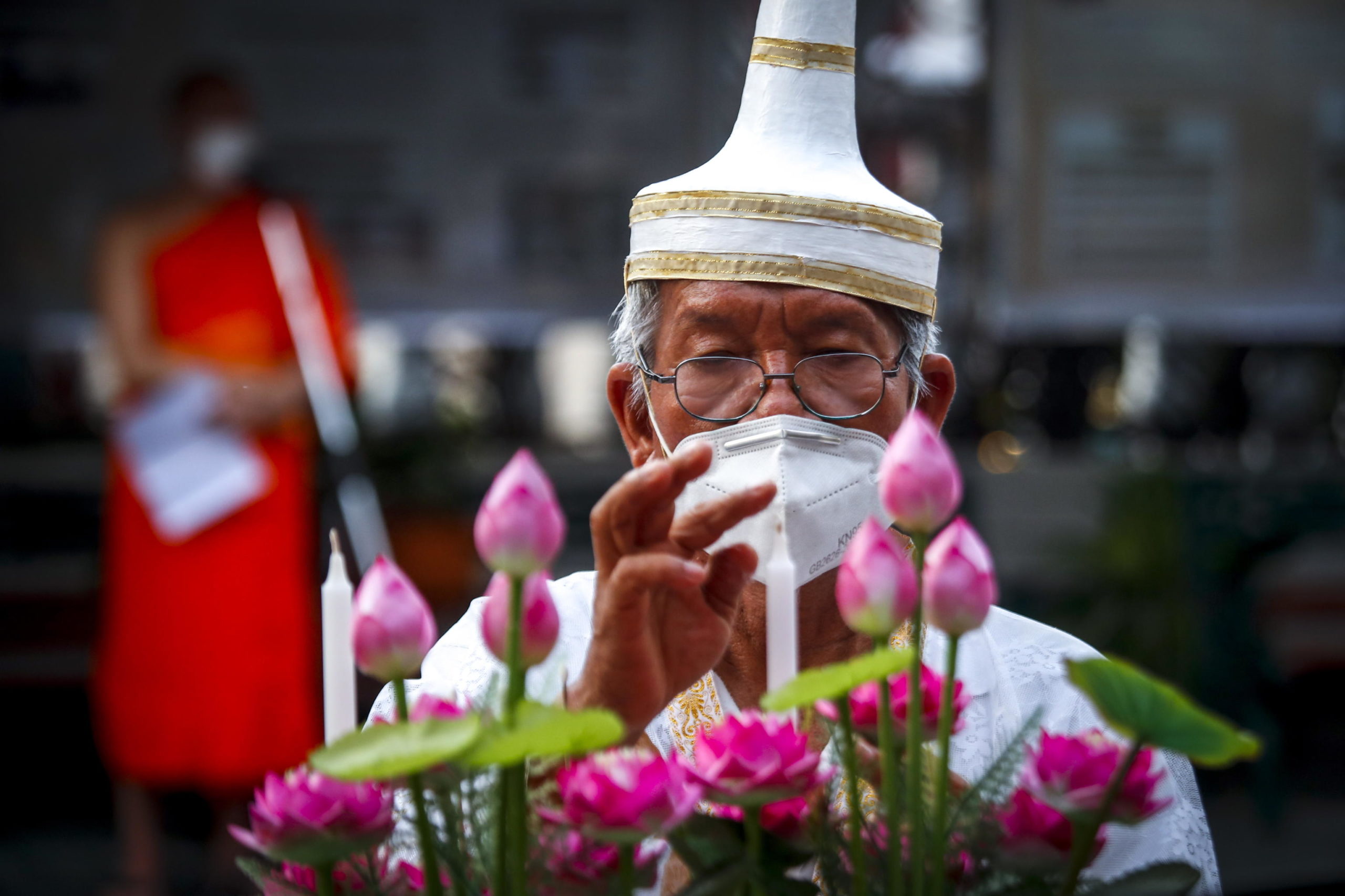 Un monaco buddista prepara le candele in vista della processione mattutina Un monaco buddista prepara le candele in vista della processione mattutina
