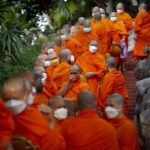 I monaci buddisti thailandesi si preparano per la processione mattutina I monaci buddisti thailandesi si preparano per la processione mattutina