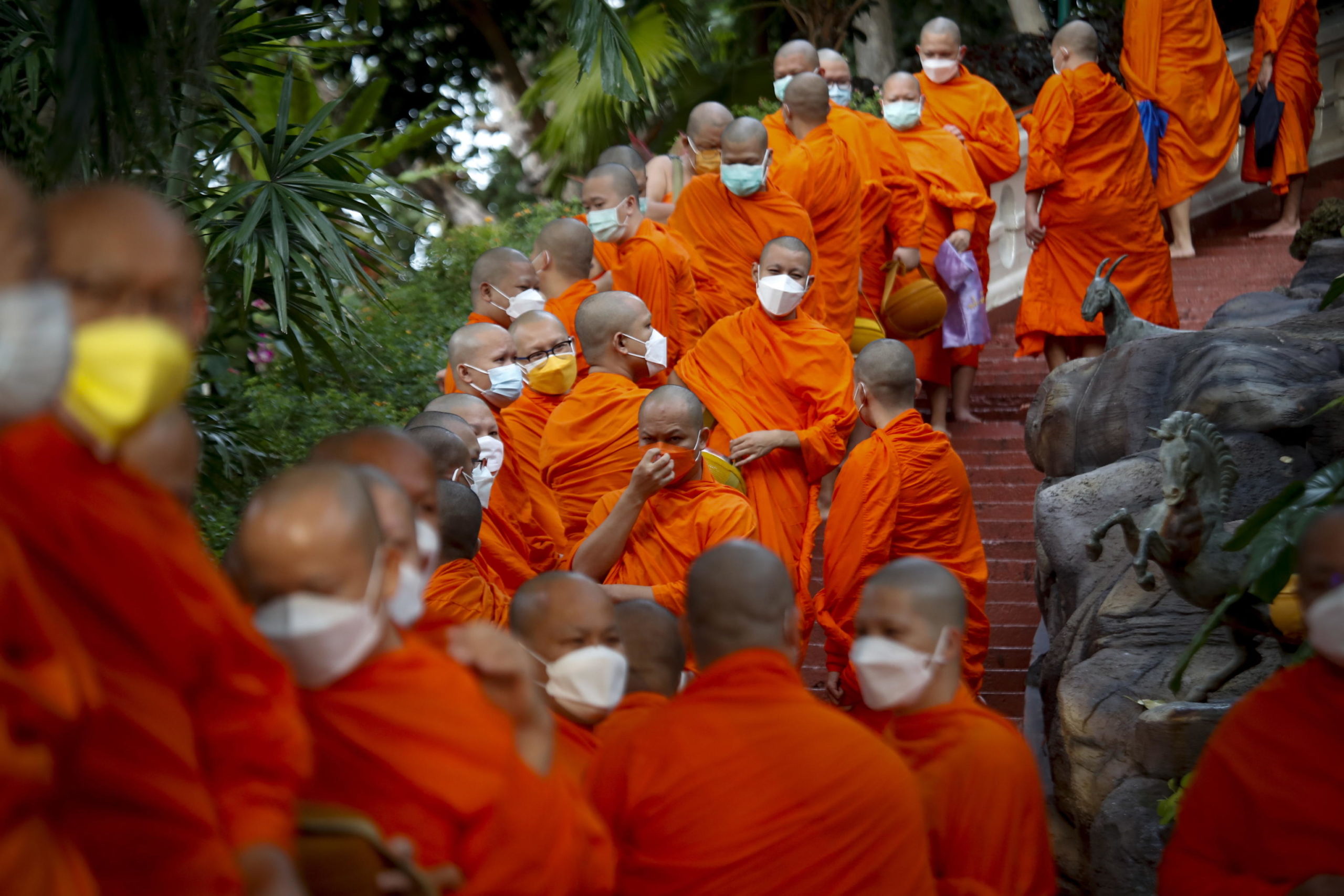 I monaci buddisti thailandesi si preparano per la processione mattutina