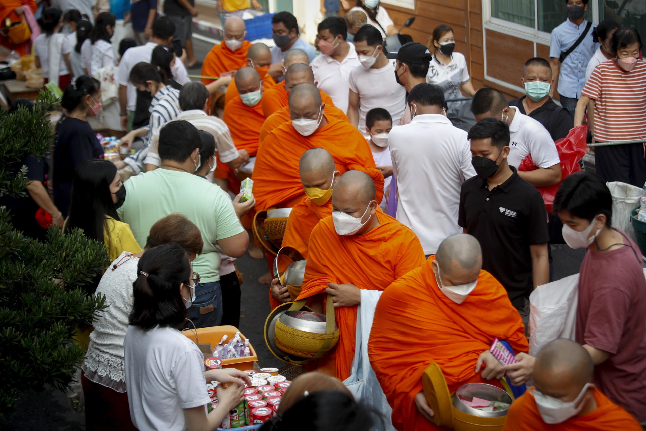 I devoti buddisti offrono candele e fiori durante il rituale dell'elemosina mattutina I devoti buddisti offrono candele e fiori durante il rituale dell'elemosina mattutina