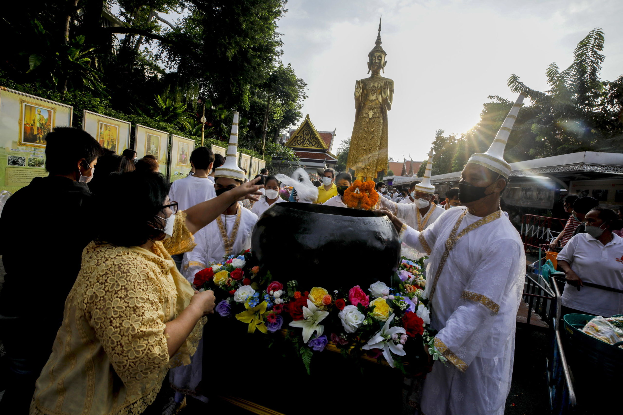 Devoti buddisti offrono candele e fiori per il rito delle offerte