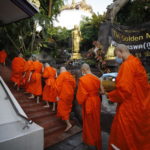 I monaci buddisti thailandesi si preparano per il rituale dell' elemosina mattutina