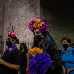 Donna vestita da catrina porta un mazzo di fiori Donna vestita da catrina porta un mazzo di fiori