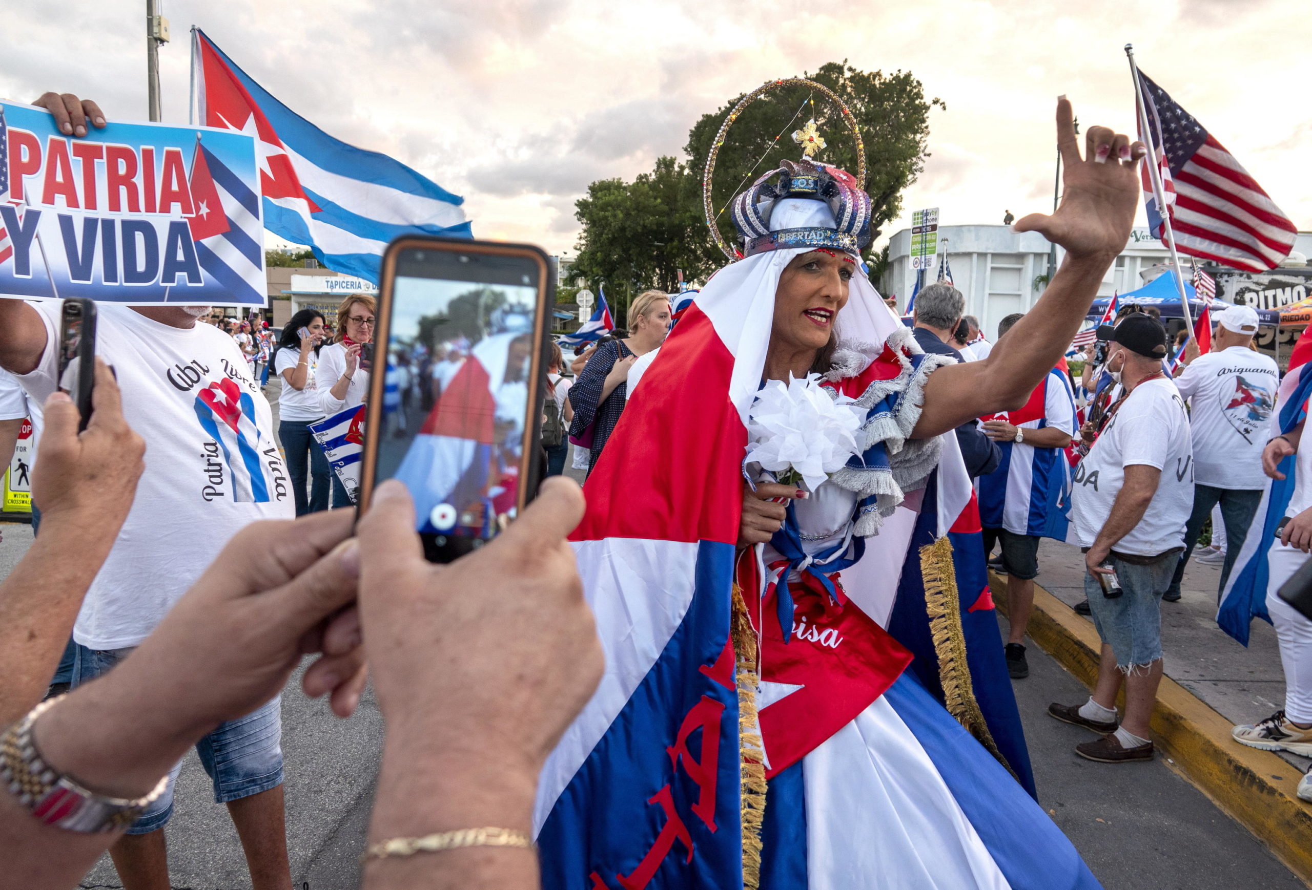 Una donna mascherata sostiene la protesta del popolo cubano contro il governo di Cuba a Miami, in Florida