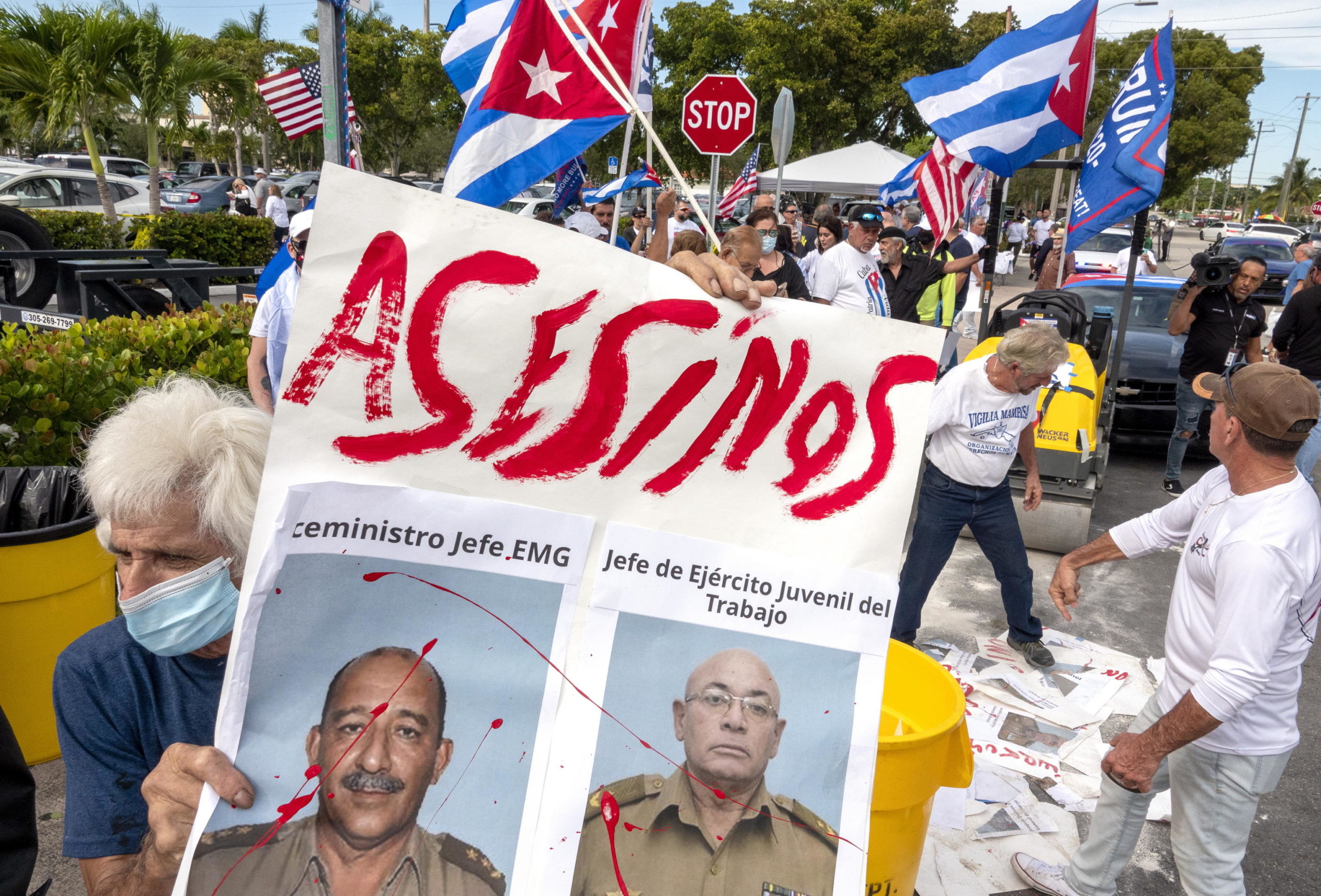 Alcuni manifestanti mostrano un cartello con scritto 'assassini' durante la protesta a supporto del popolo cubano contro il governo di Cuba a Miami, in Florida