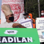 Un attivista indonesiano mostra il suo manifesto di protesta chiedendo "giustizia"
