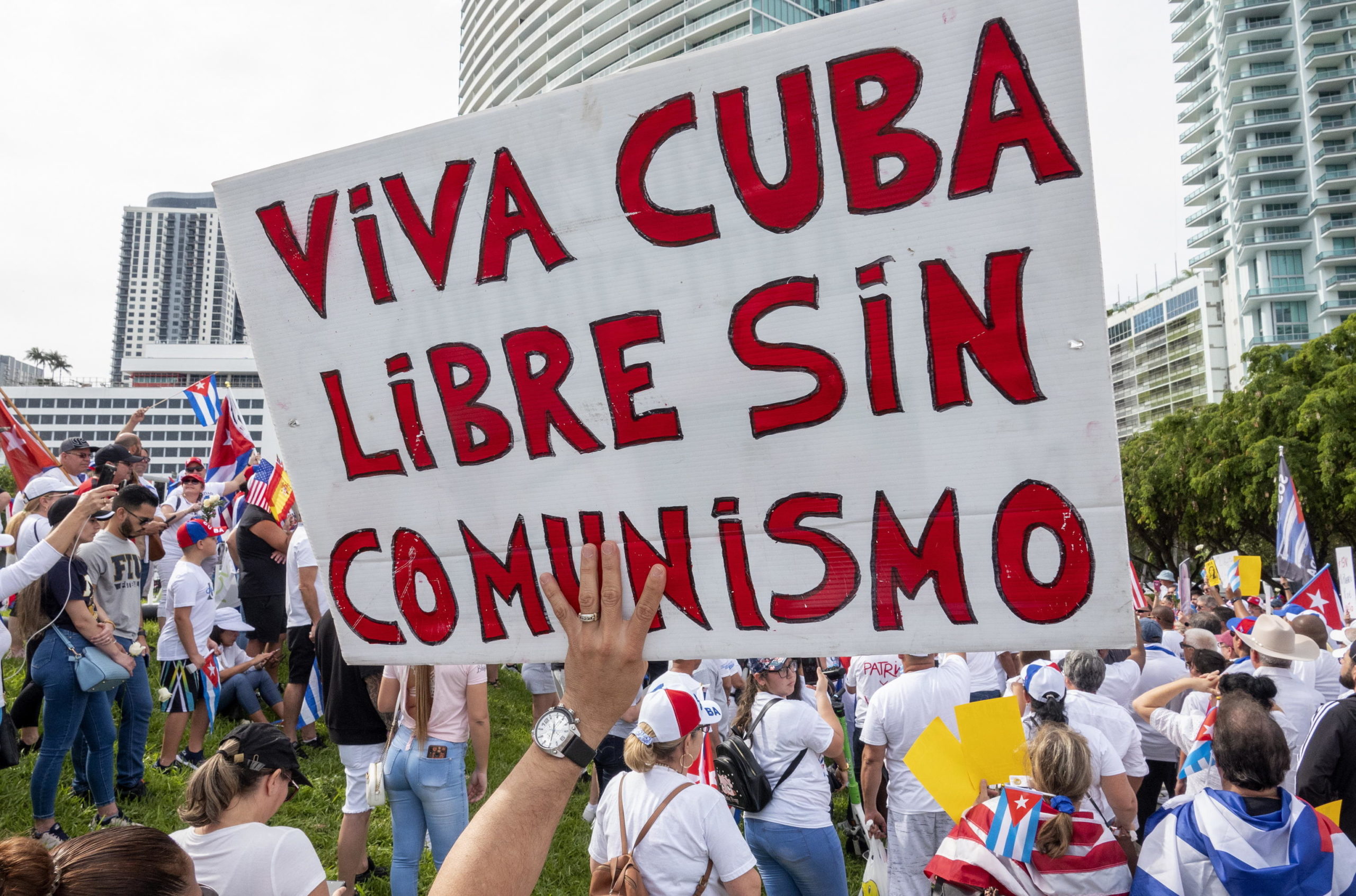 Un cartello chiede Cuba libera senza il comunismo. Sullo sfondo la manifestazione contro il governo cubano a Miami, in Florida