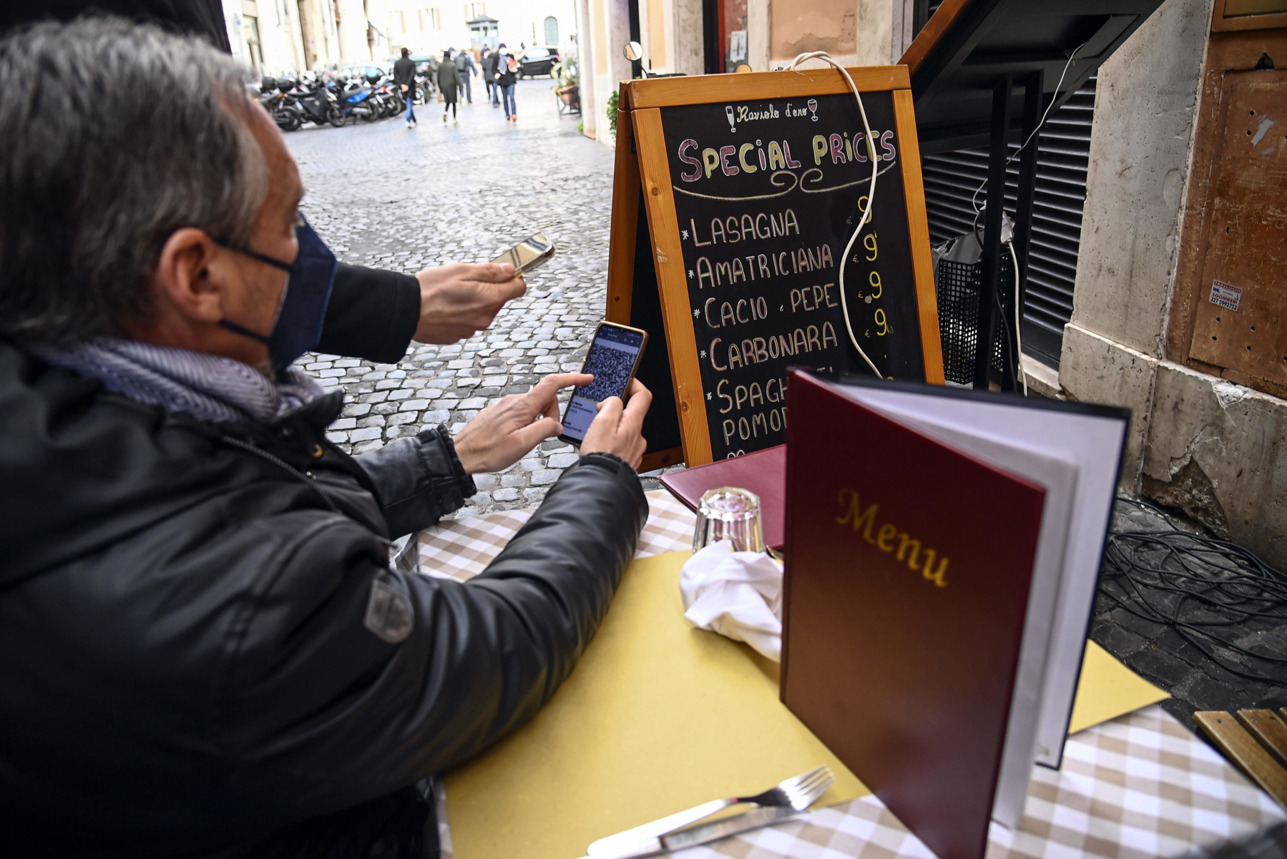 Controllo del super green pass ad un cliente seduto in un posto all'aperto di un ristorante