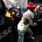 Un uomo cerca di forzare il cordone formato dagli agenti