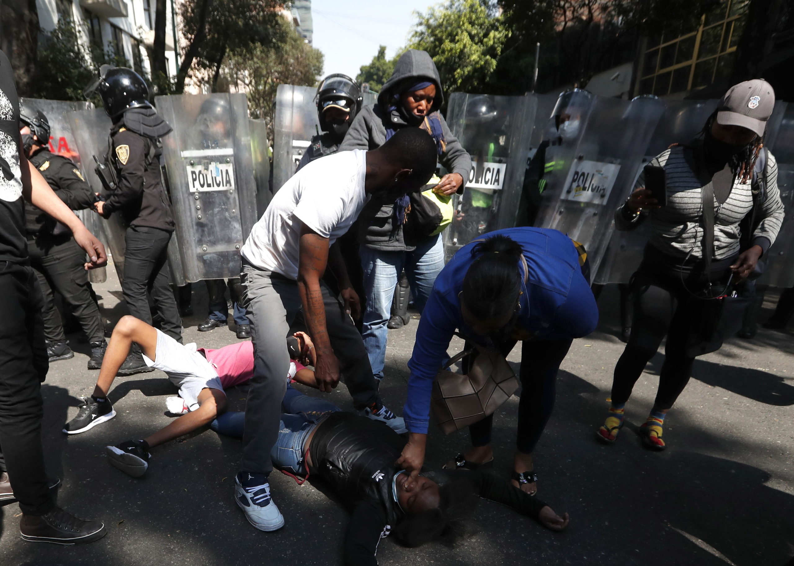 Un uomo e una donna soccorrono una manifestante rimasta ferita negli scontri