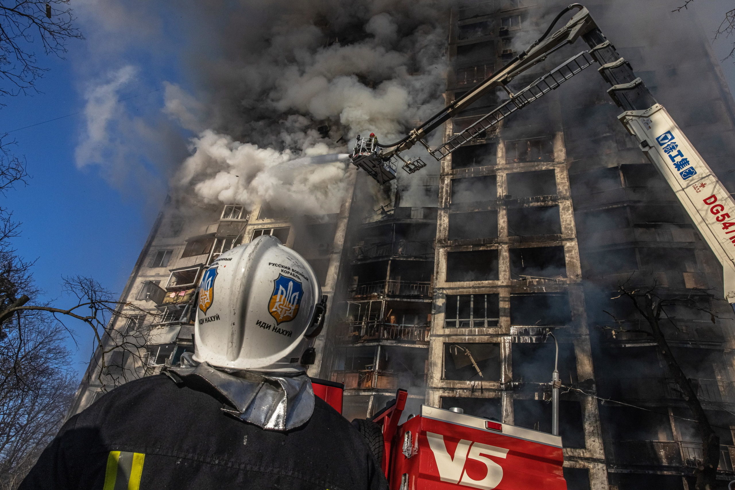 Un vigile del fuoco guarda il fumo che esce dall'edificio devastato dalle bombe