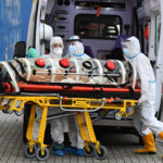 A Roma alcuni infermieri trasportano un paziente infetto da Covid-19 su una barella di biocontenimento