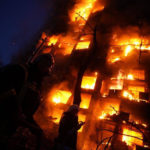 L'incendio avvolge il palazzo bombardato alle luci dell'alba dalle truppe russe a Kiev
