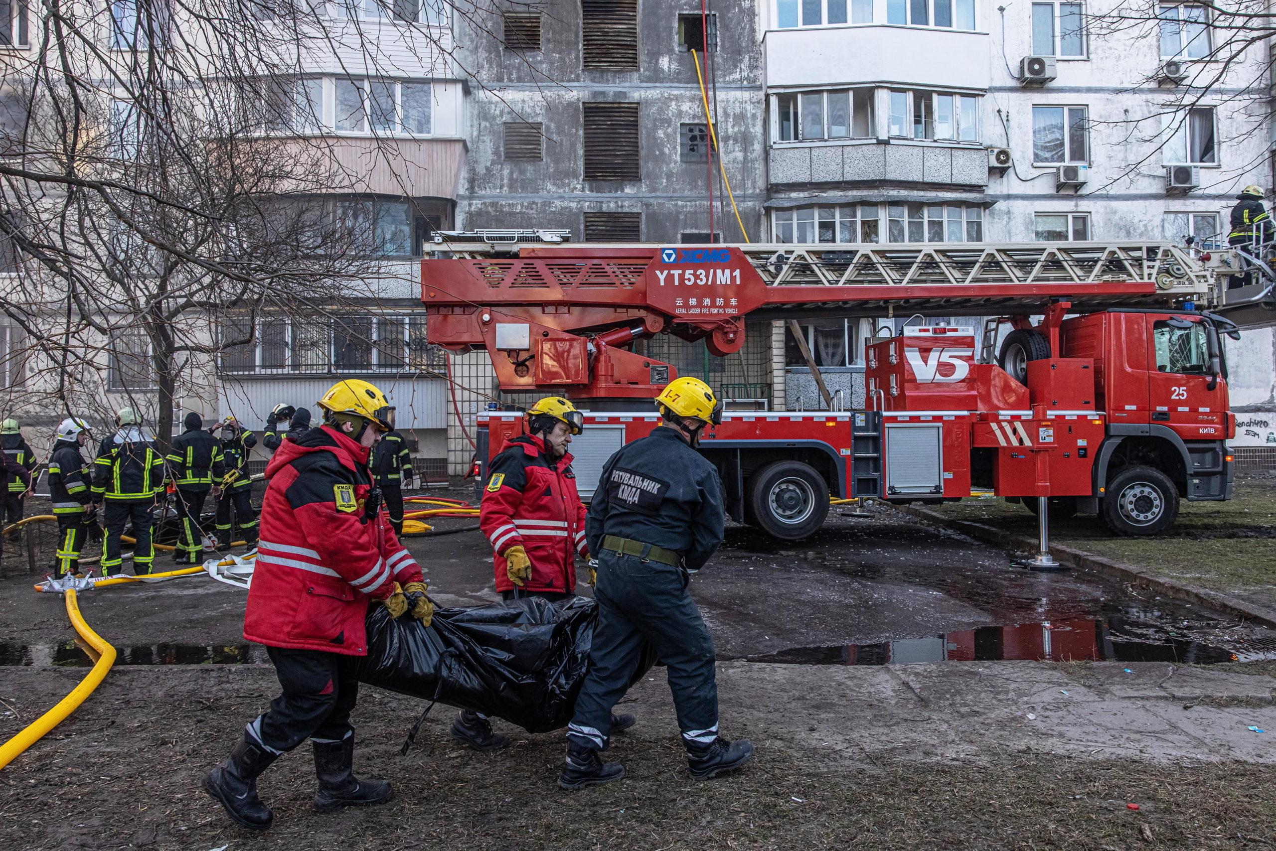 Due vigili del fuoco trasportano una delle due vittime del bombardamento Due vigili del fuoco trasportano una delle due vittime del bombardamento