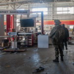 Poliziotti ucraini e militari del Comando di difesa territoriale trasportano merci da un negozio danneggiato per metterle al sicuro dopo i bombardamenti a Kharkiv