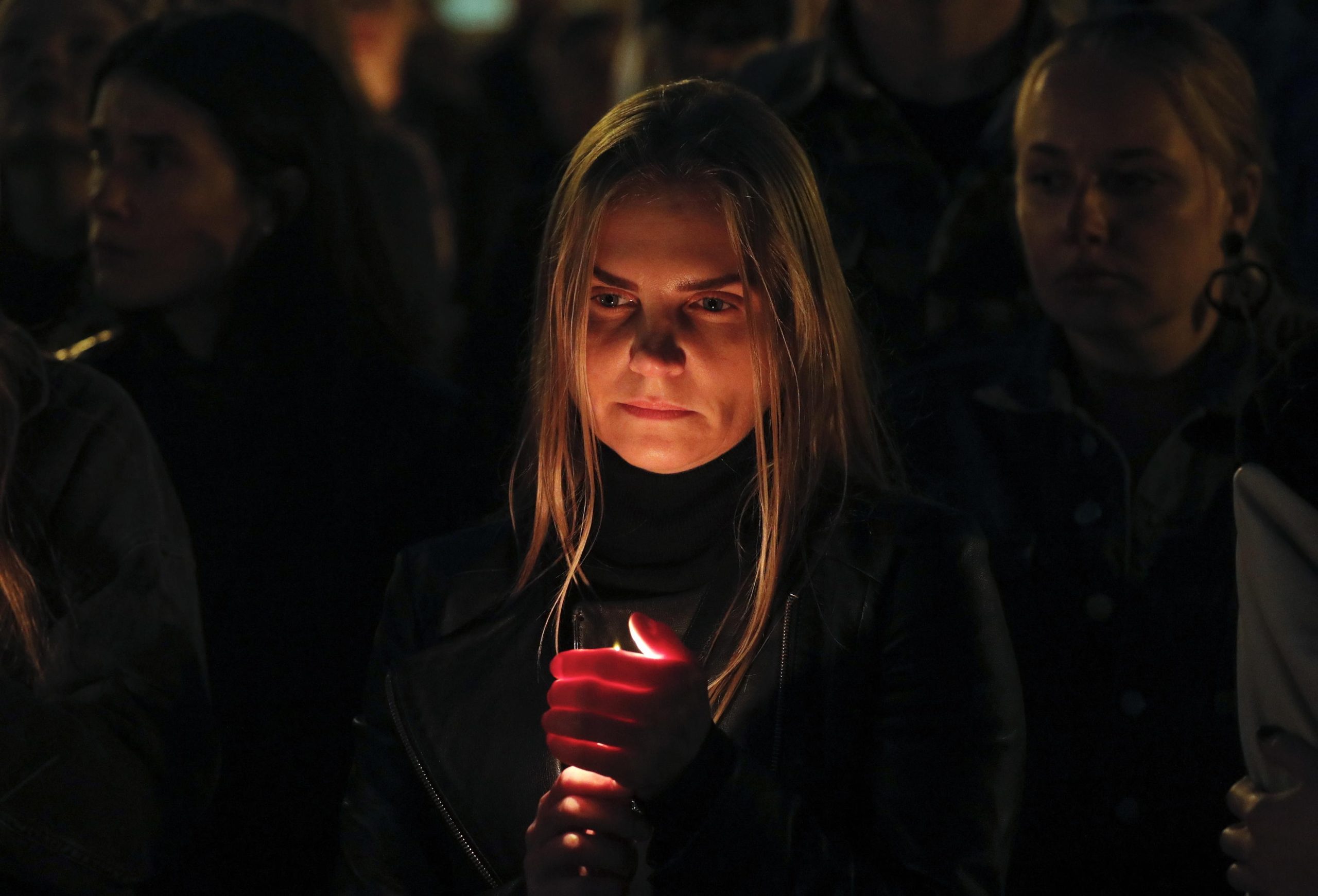 Una donna regge una candela accesa a Kiev, nel corso della manifestazione in memoria delle vittime del centro di Olenivka