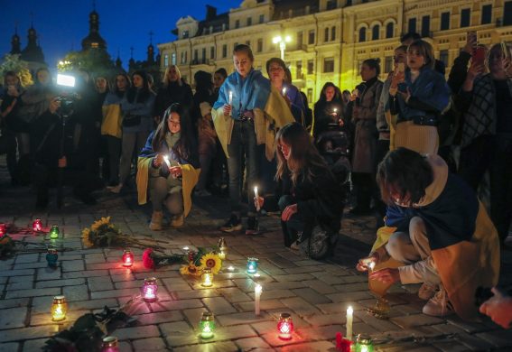 Manifestanti accendono delle candele a Kiev, per terra dei fiori in memoria delle vittime del centro di Olenivka