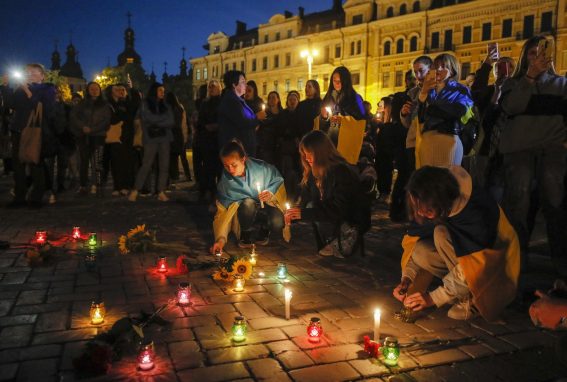 Manifestanti accendono delle candele a Kiev, per terra dei fiori in memoria delle vittime del centro di Olenivka