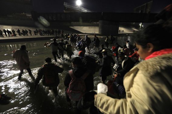Un gruppo di migranti attraversa il fiume Rio Grande vicino Ciudad Juárez in Messico