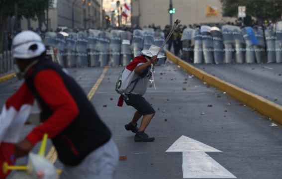 La polizia peruviana in tenuta antisommossa pronta a schermare l'attacco dei protestanti