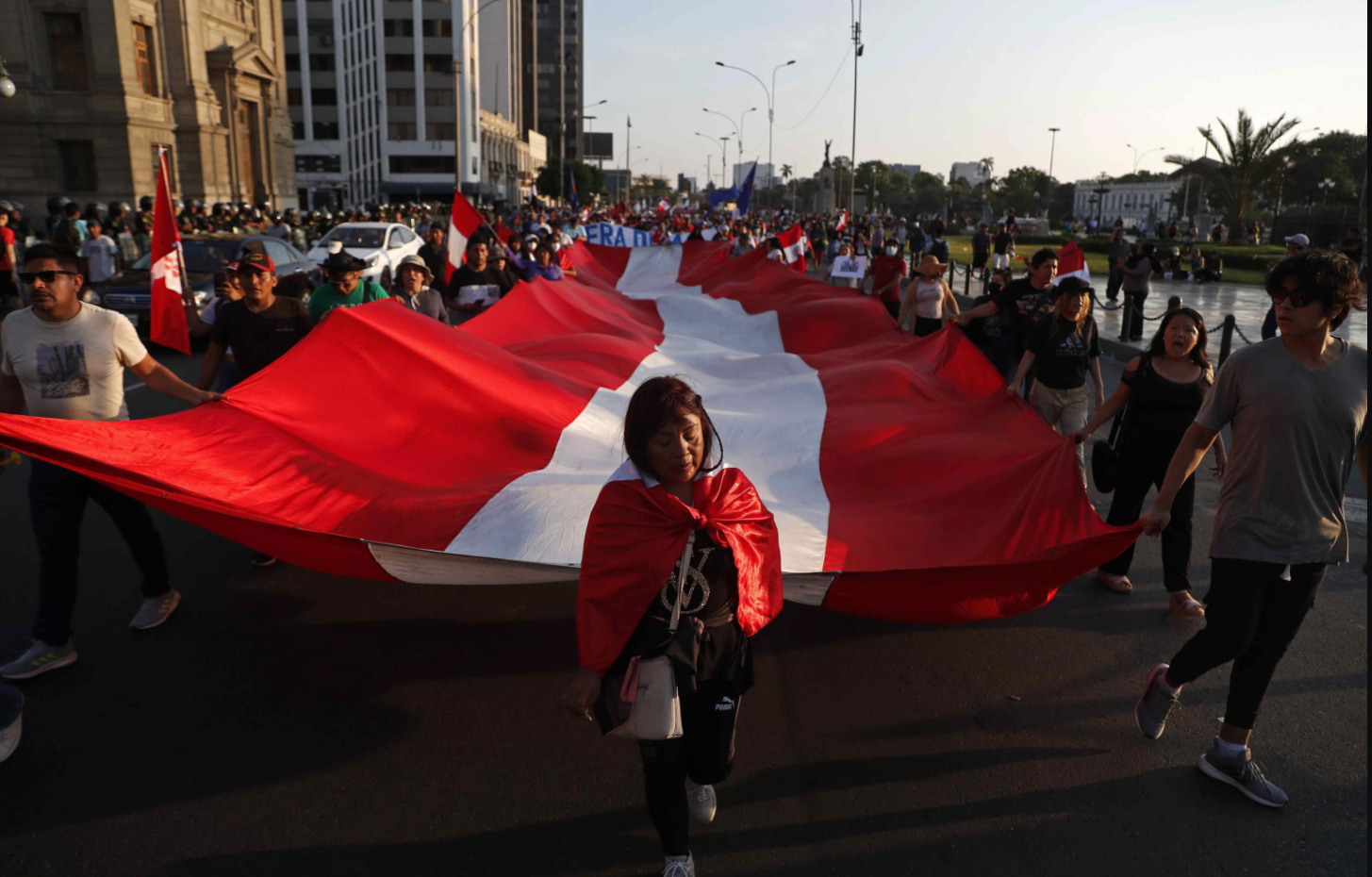 Una bandiera del Perù sfila tra le strade dalla capitale sorretta dal corteo