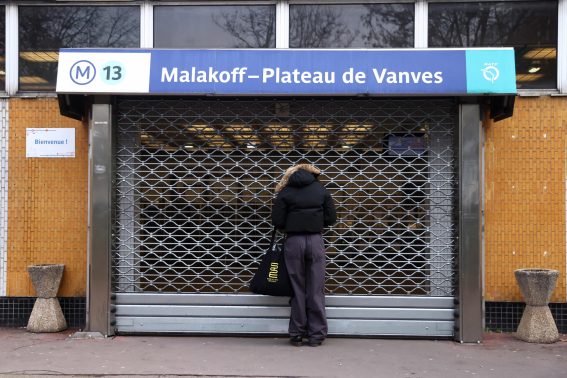 Un pendolare guarda una stazione della metropolitana chiusa a Parigi durante lo sciopero nazionale