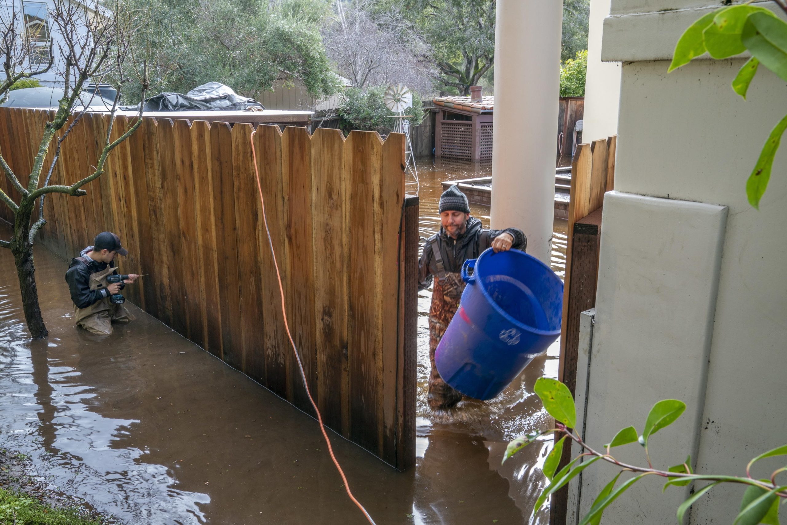 Un uomo cerca di liberare dall'acqua il proprio cortile