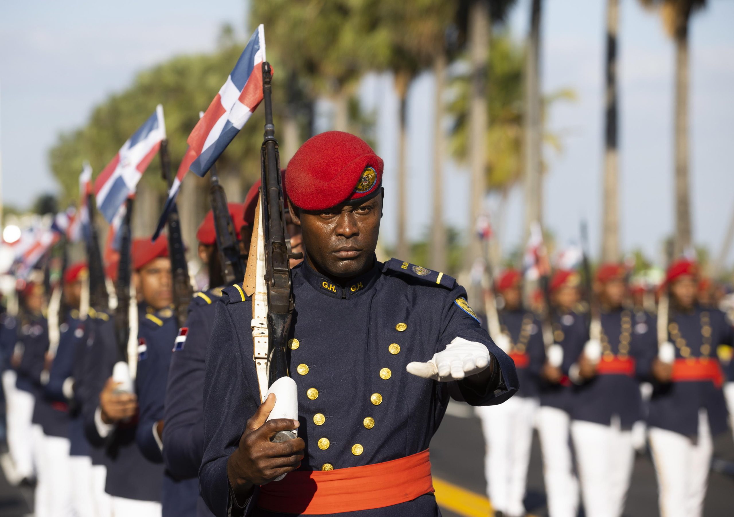 Membri delle forze armate sfilano alla parata militare portando la bandiera della Repubblica Domenicana