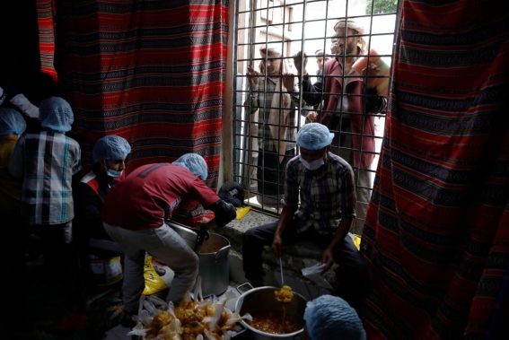 Un gruppo di persone attende di ricevere del cibo per l'iftar da un'associazione umanitaria a Sanaa, in Yemen, il 27 marzo 2023