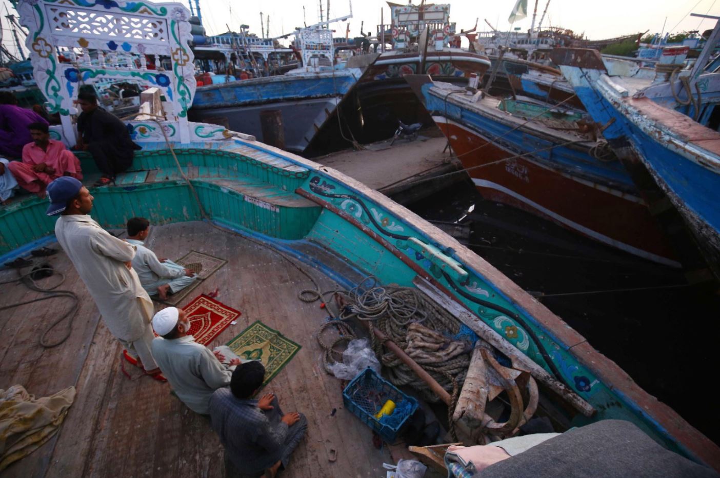 Pescatori pakistani pregano sulla loro barca, a Karachi, il 27 marzo 2023