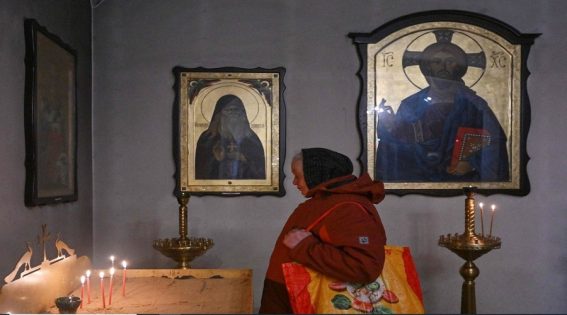 Una donna anziana prega nella chiesa di Sant'Andrea e tutti i Santi di Pyervozvannoho a Bucha, 30 marzo 2023.