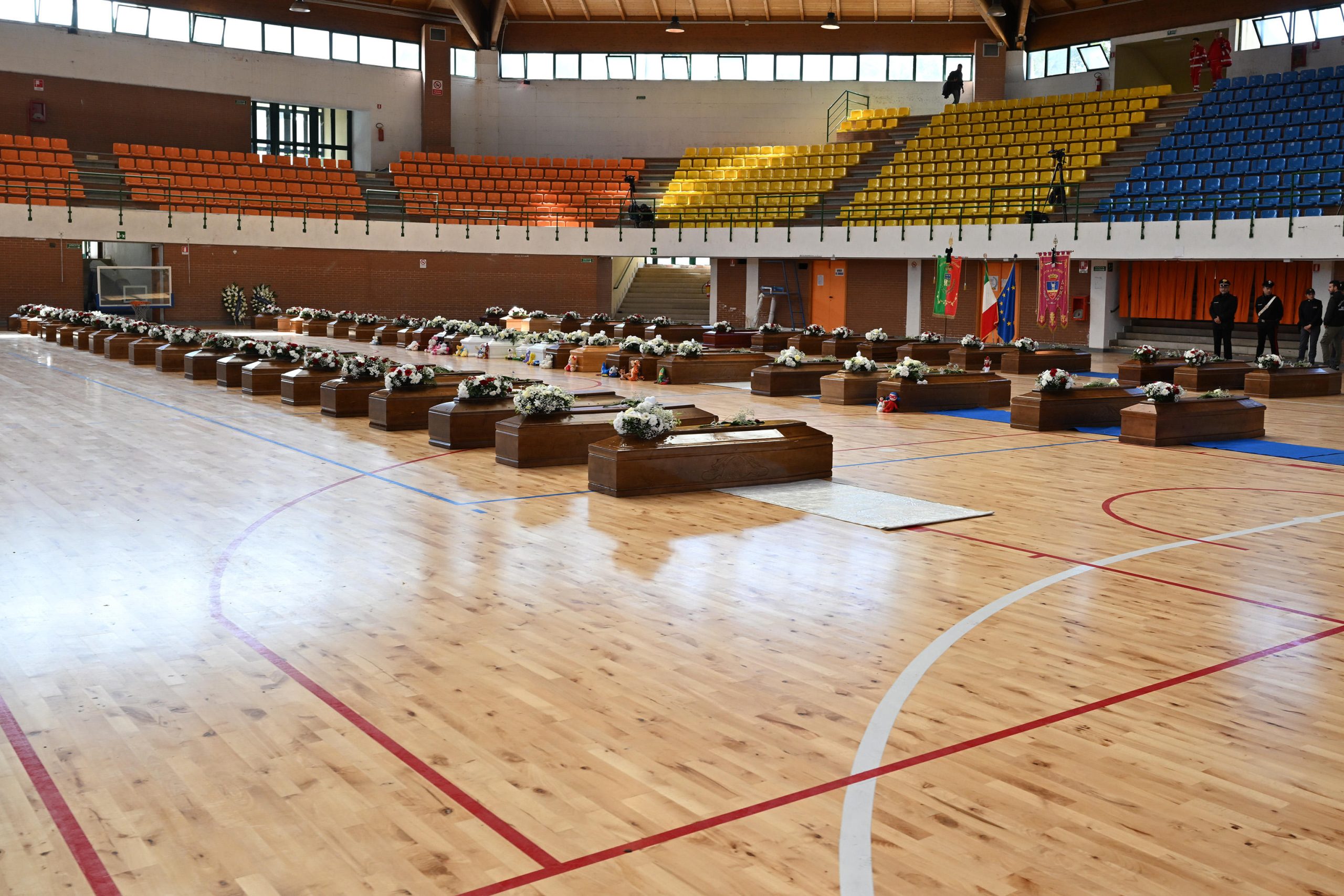 Le bare dei migranti morti nella tragedia di Cutro disposte in fila al PalaMilone