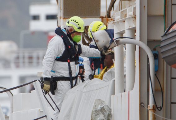 Soccorritore che sorride a un bambino dopo lo sbarco dalla nave Diciotti