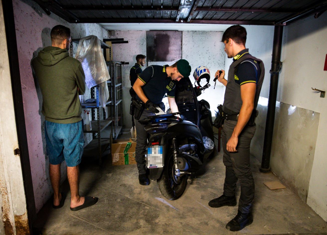 I militari della Guardia di Finanza controllano un motorino sospetto all'interno di un garage I militari della Guardia di Finanza controllano un motorino sospetto all'interno di un garage