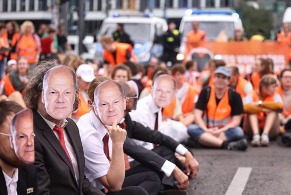 Gli attivisti, nel corso delle proteste, hanno indossato maschere del cancelliere tedesco Olaf Scholz